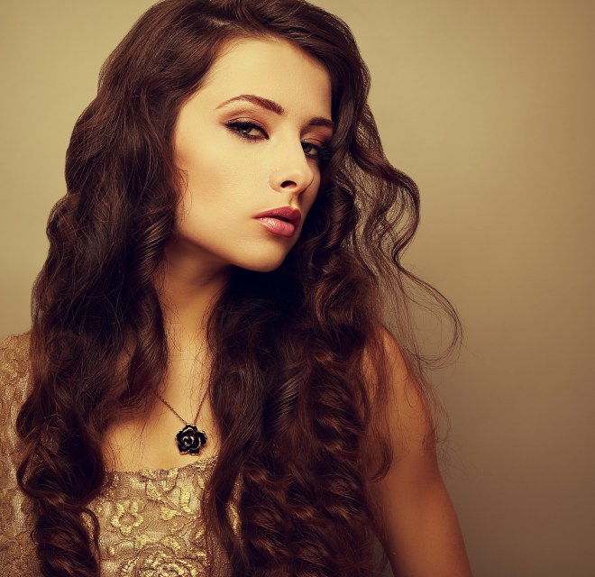 Beautiful bright makeup woman with long curly hair looking sexy
